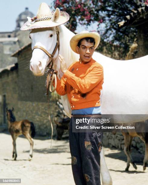 Mexican actor and comedian Cantinflas , with a white horse wearing a straw hat, in 'Pepe', directed by George Sidney, 1960. Cantinflas plays the...