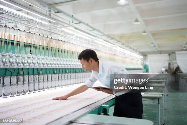 skilled worker inspecting loom - guangdong province stock pictures, royalty-free photos & images