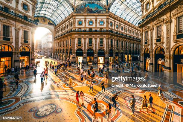 crowd of people in galleria vittorio emanuele ii at sunset, milan, italy - europe travel stock-fotos und bilder
