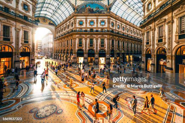 crowd of people in galleria vittorio emanuele ii at sunset, milan, italy - high end store fronts stock-fotos und bilder