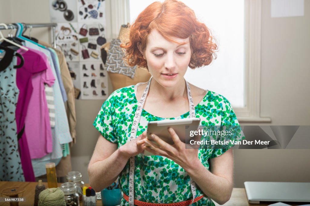 Fashion designer working on digital tablet .