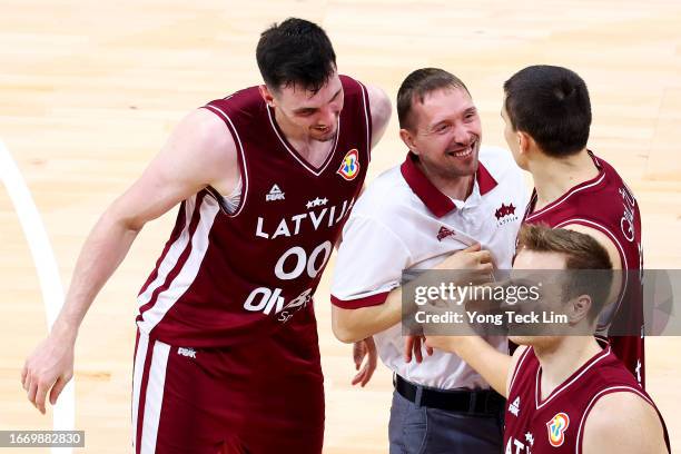 Rodions Kurucs and Andrejs Grazulis of Latvia celebrate with a team official after the FIBA Basketball World Cup Classification 5-6 game victory over...