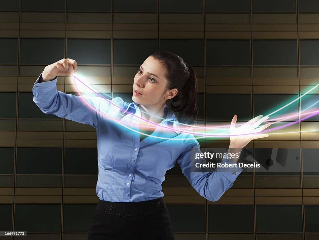 Business woman controlling light trails