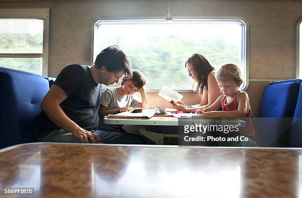 mother father and kids travelling by train - train photos et images de collection