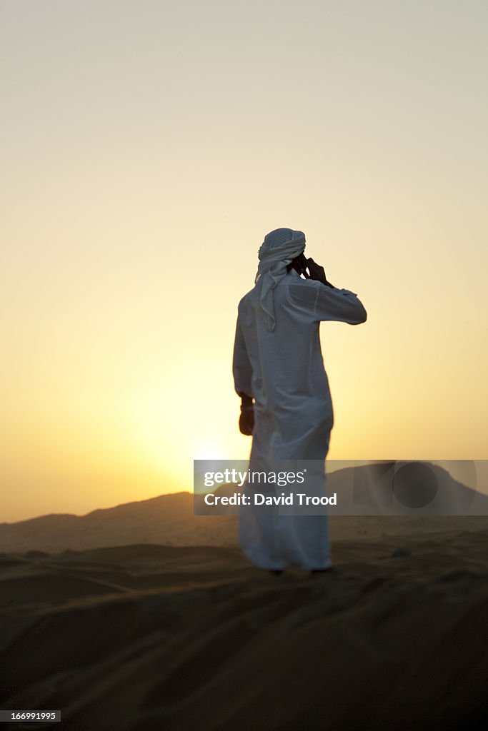 Middle Eastern man talking on in Desert near Dubai