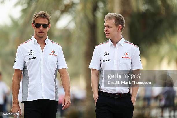 Jenson Button of Great Britain and McLaren and Kevin Magnussen of Finland and McLaren walk in the paddock following practice for the Bahrain Formula...