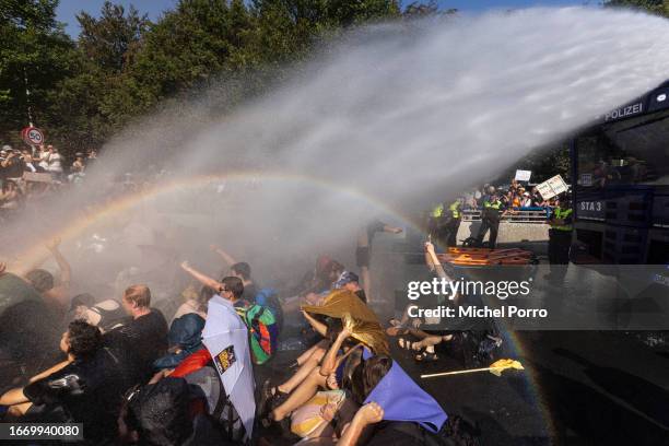 Extinction Rebellion activists are sprayed by a police water cannon as they block the A12 motorway in protest against the government’s support for...