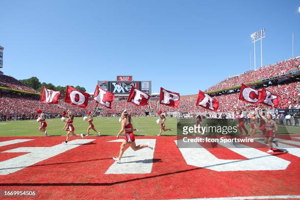 The North Carolina State Wolfpack cheerleaders run the flags after a score during the college football game between the North Carolina State Wolfpack...