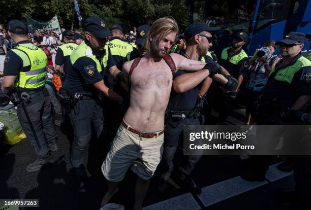 An Extinction Rebellion activist is arrested by police after he blocked the A12 motorway in protest against the government’s support for the fossil...