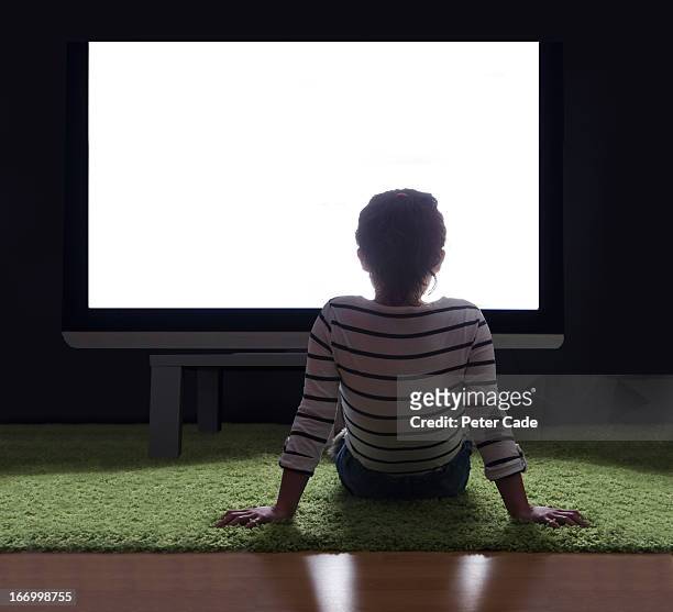 girl sat on floor in front of large white screen - watching tv rear view stock pictures, royalty-free photos & images