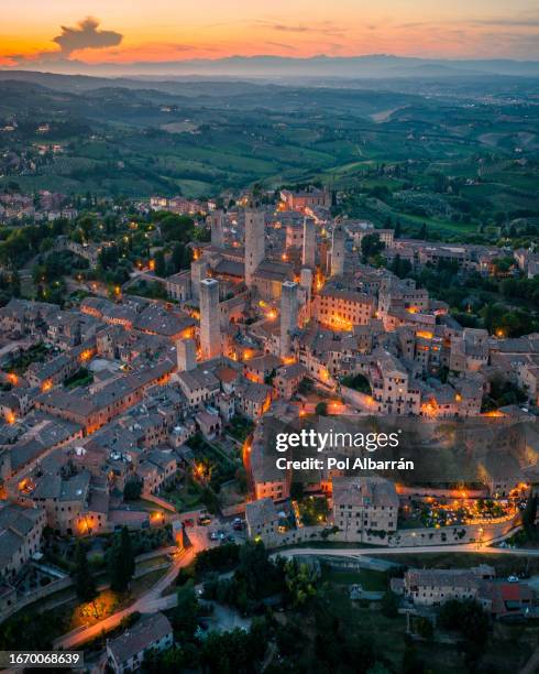 san gimignano town at night with its skyline of medieval towers, including the stone torre grossa. unesco world heritage site. province of siena, tuscany, italy - siena province - fotografias e filmes do acervo