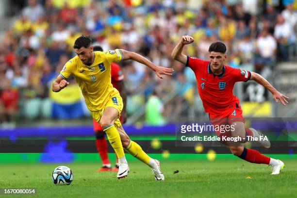 Roman Yaremchuk of Ukraine runs with the ball under pressure from Declan Rice of England during the UEFA EURO 2024 European qualifier match between...