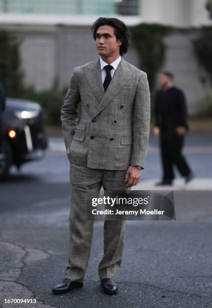 Charles Melton is seen outside Ralph Lauren show wearing a full Ralph Lauren look, checkered and slim fitted greige Ralph Lauren suit and matching...