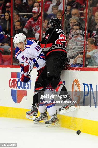 Derick Brassard of the New York Rangers checks Bobby Sanguinetti of the Carolina Hurricanes into the boards during play at PNC Arena on April 6, 2013...