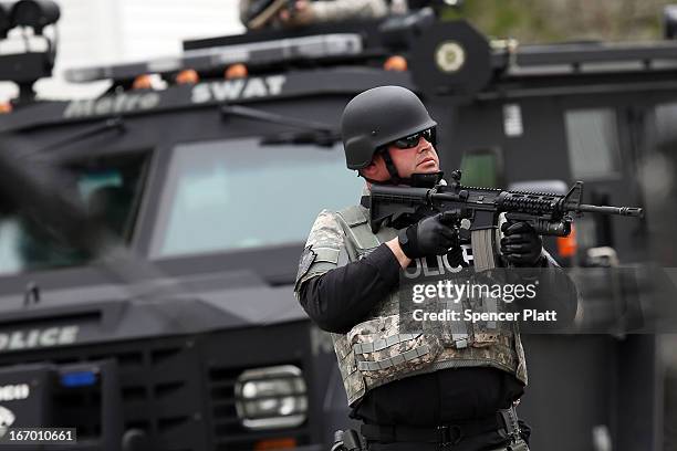 Members of a police S.W.A.T. Team search through a neighborhood in Watertown as they search for 19-year-old bombing suspect Dzhokhar A. Tsarnaev on...