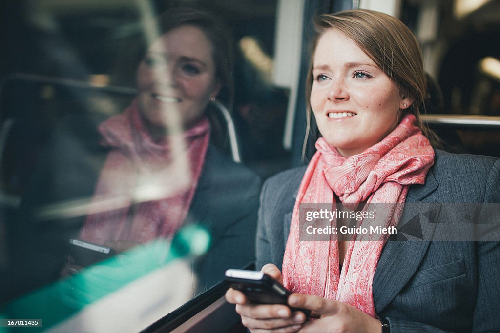 Woman using smart phone in subway.