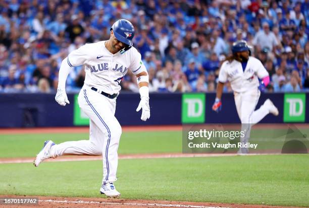 Whit Merrifield of the Toronto Blue Jays runs out his walk off single as Vladimir Guerrero Jr. #27 scores the winning run in the thirteenth inning...