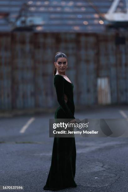 Camila Coelho is seen outside Ralph Lauren show wearing gold earrings and a dark green velvet Ralph Lauren body fitted dress on September 08, 2023 in...