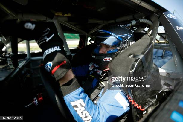 Chris Buescher, driver of the Fastenal Ford, sits in his car during qualifying for the NASCAR Cup Series Hollywood Casino 400 at Kansas Speedway on...