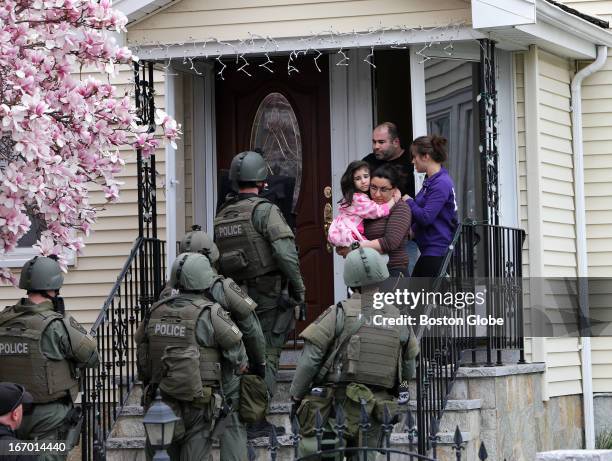 Teams conduct a house to house search in an area near last night's shootout during the ongoing manhunt for a suspect in the terrorist bombing of the...