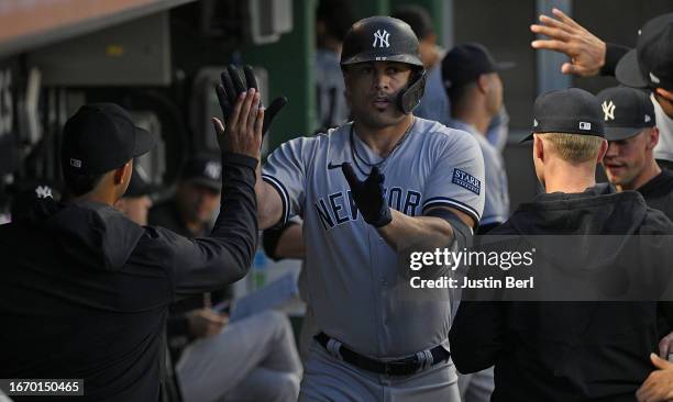 Giancarlo Stanton of the New York Yankees celebrates with teammates in the dugout after hitting a solo home run in the third inning during the game...