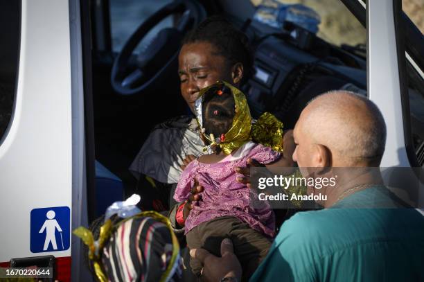 Sanitary man passes a child to her mother in Lampedusa, Italy on September 16, 2023. The small Sicilian island of Lampedusa is overwhelmed with...