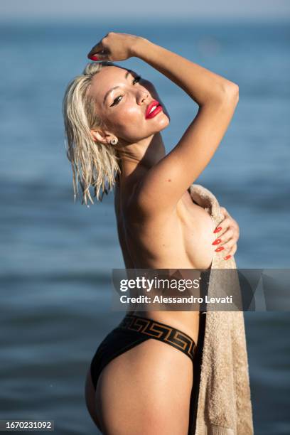 Aliia Roza poses on the beach for the photographer during the 80th Venice International Film Festival on September 09, 2023 in Venice, Italy.