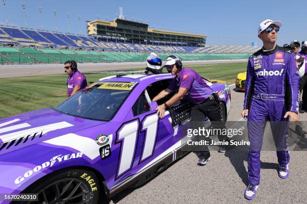 Denny Hamlin, driver of the Yahoo! Toyota, and crew walk the grid during qualifying for the NASCAR Cup Series Hollywood Casino 400 at Kansas Speedway...
