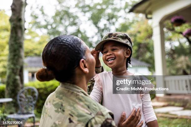 daughter laughing with female u.s. soldier mother in front of home - kid power event in atlanta stock pictures, royalty-free photos & images