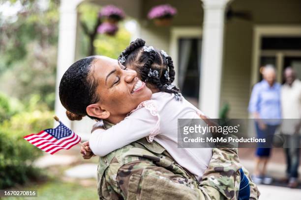 daughter embracing female u.s. soldier mother in front of home - 米退役軍人の日 ストックフォトと画像
