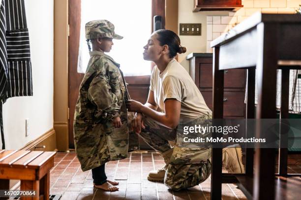 daughter wearing u.s. soldier mother's uniform at home - child saluting stock pictures, royalty-free photos & images