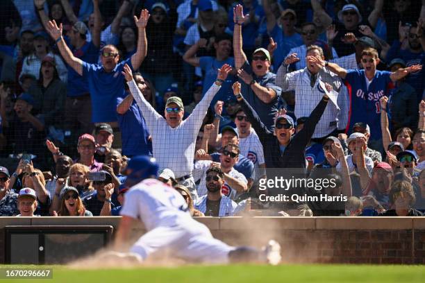 Chicago Cubs fans react after Nico Hoerner of the Chicago Cubs scored in the third inning against the Arizona Diamondbacks at Wrigley Field on...