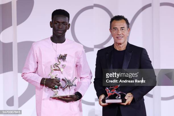 Seydou Sarr and Matteo Garrone pose with the Marcello Mastroianni Award for Best New Young Actor or Actress and the Silver Lion for Best Director for...