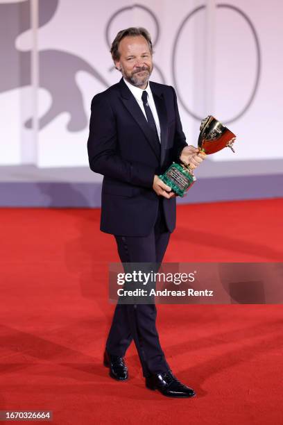 Peter Sarsgaard poses with the Best Actor Award for 'Memory' at the winner's photocall at the 80th Venice International Film Festival on September...