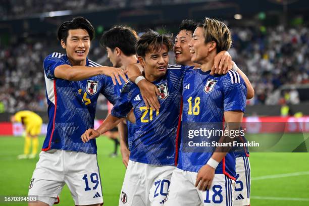 Takuma Asano of Japan celebrates with teammates after scoring the team's third goal during the international friendly match between Germany and Japan...