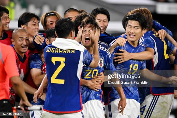 Ao Tanaka of Japan celebrates with teammates after scoring the team's fourth goal during the international friendly match between Germany and Japan...