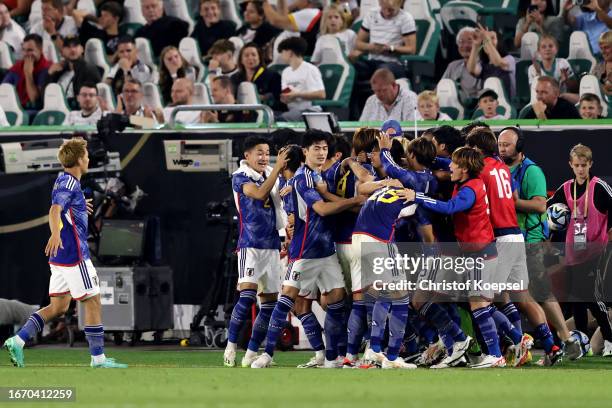Ao Tanaka of Japan celebrates with teammates after scoring the team's fourth goal during the international friendly match between Germany and Japan...
