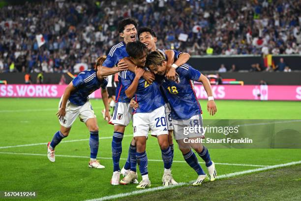 Takuma Asano of Japan celebrates with teammates after scoring the team's third goal during the international friendly match between Germany and Japan...