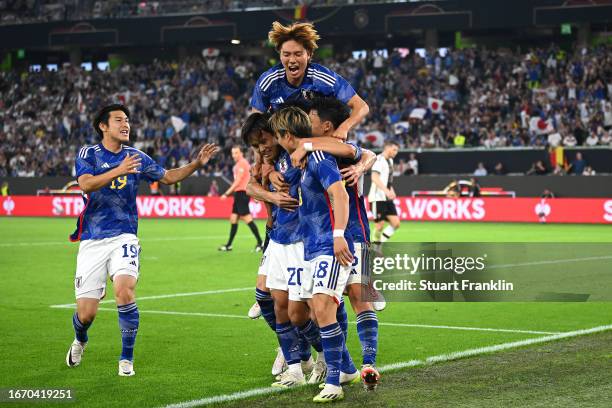 Takuma Asano of Japan celebrates with teammates after scoring the team's third goal during the international friendly match between Germany and Japan...