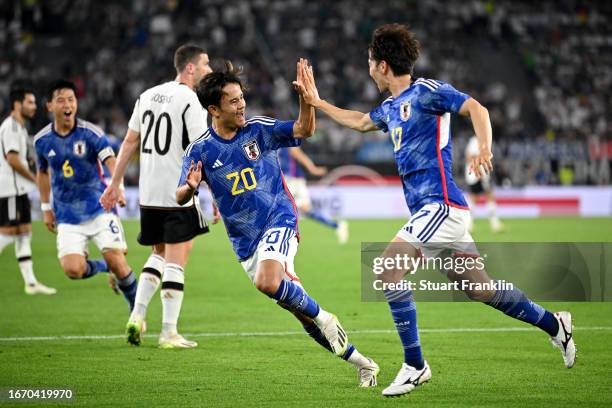 Ao Tanaka of Japan celebrates with teammate Takefusa Kubo after scoring the team's fourth goal during the international friendly match between...