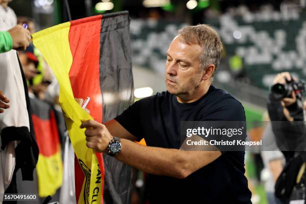 Hansi Flick, Head Coach of Germany writes autographs after the team's defeat in the international friendly match between Germany and Japan at...