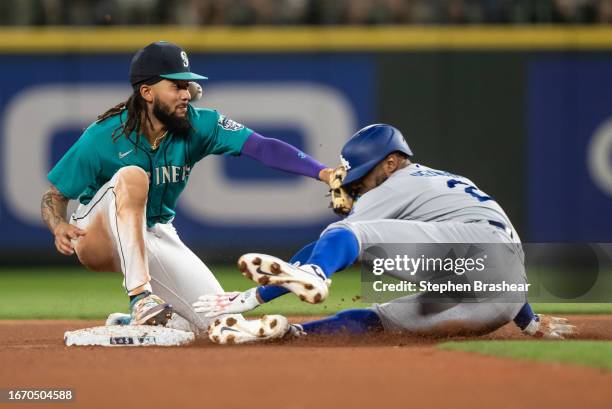 Jason Heyward of the Los Angeles Dodgers slides safely into second base ahead of a tag by shortstop J.P. Crawford of the Seattle Mariners during the...