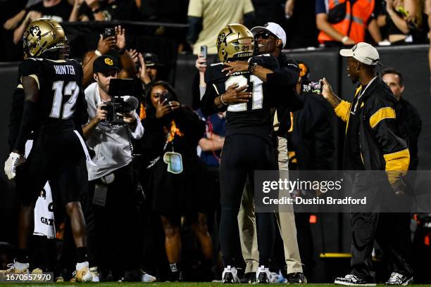 Safety Shilo Sanders of the Colorado Buffaloes celebrates with head coach Deion Sanders after scoring a touchdown after an interceprtion against the...