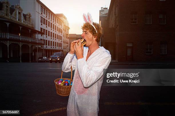 easter bunny eating burger - easter and humour stockfoto's en -beelden