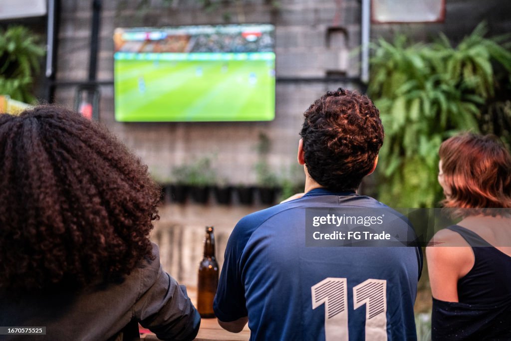 Sportfans, die sich ein Spiel in der Bar ansehen