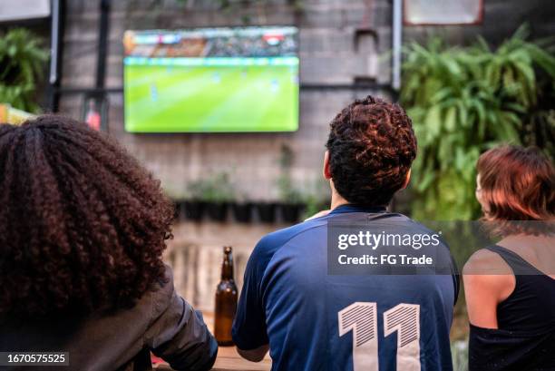 sports fans watching a match at bar - watching tv bildbanksfoton och bilder