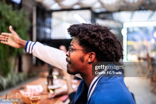 young man watching a match at bar - complaining stock pictures, royalty-free photos & images