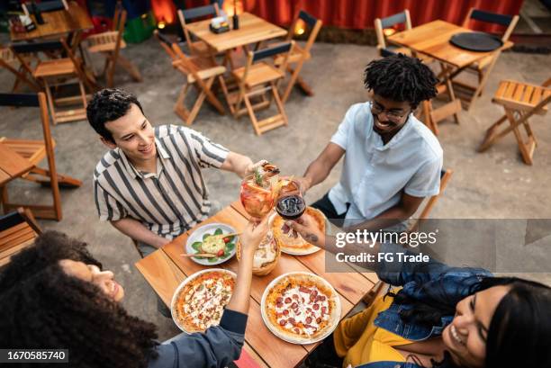 des amis trinquent avec un verre au bar - pizzeria photos et images de collection