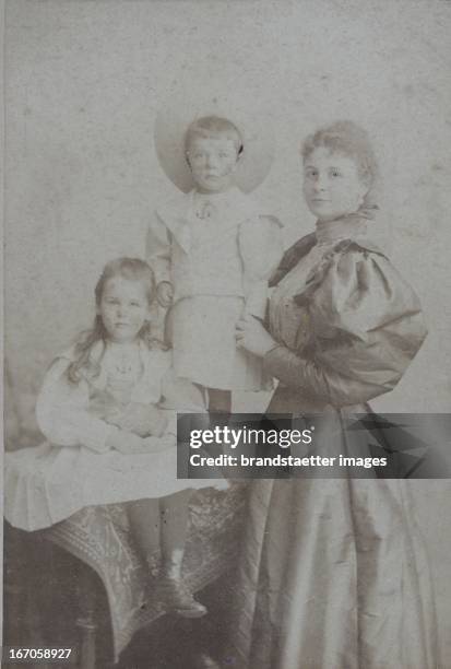 Mother with two children. About 1890. Photograph by Alexander Fink / Pressburg. Photograph. Mutter mit zwei Kindern. Um 1890. Photographie von...