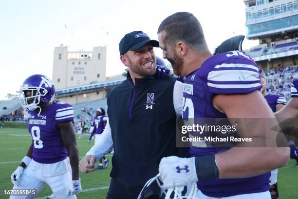 Interim head coach David Braun of the Northwestern Wildcats celebrates with Bryce Gallagher after defeating the UTEP Miners 38-7 for his first career...